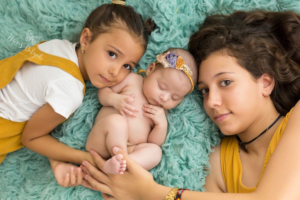 hermanas en sesión de foto con happy baby